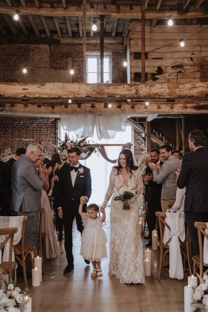 Bride, groom and daughter standing together during Godwick Hall ceremony