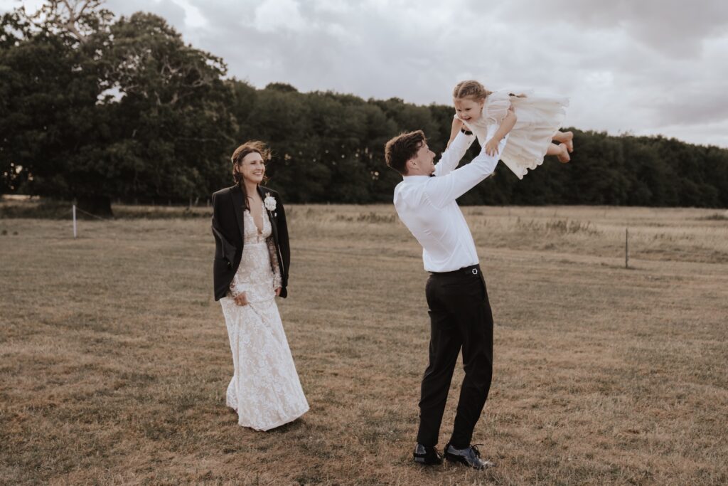 Bride, groom and daughter during sunset portraits at Godwick Hall
