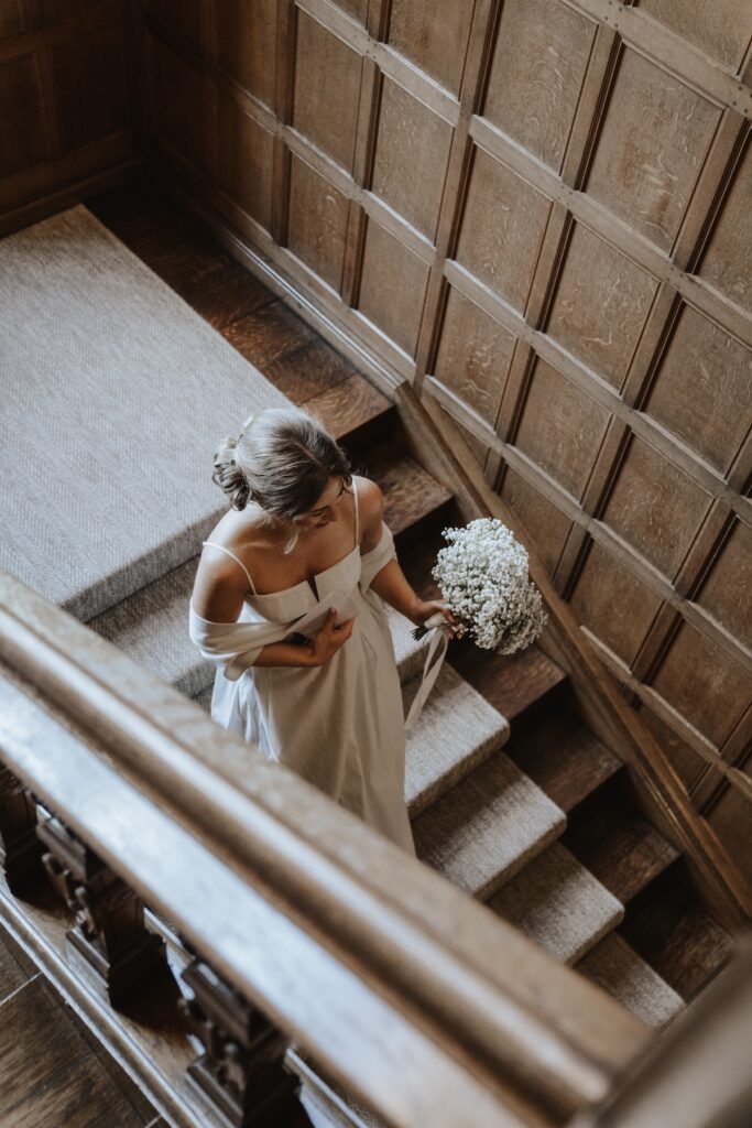 Bride walking down the grand staircase at Hengrave Hall