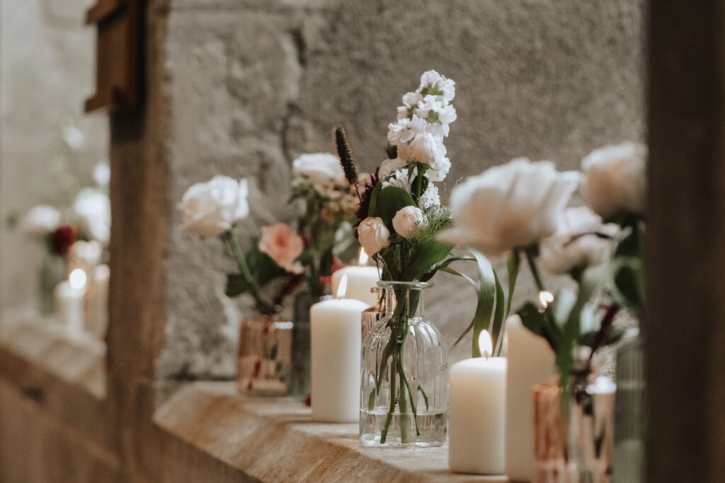 Candles and floral bud vases lining the aisle inside Hengrave Hall chapel