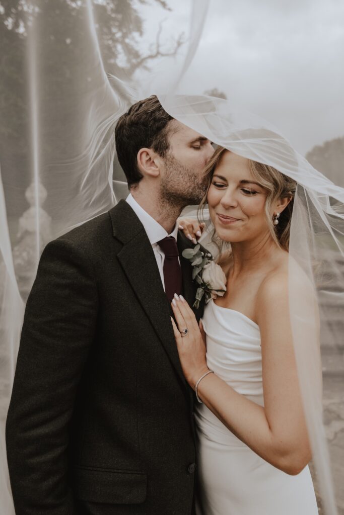 Romantic portrait of the couple outside the grand front doors of Hengrave Hall