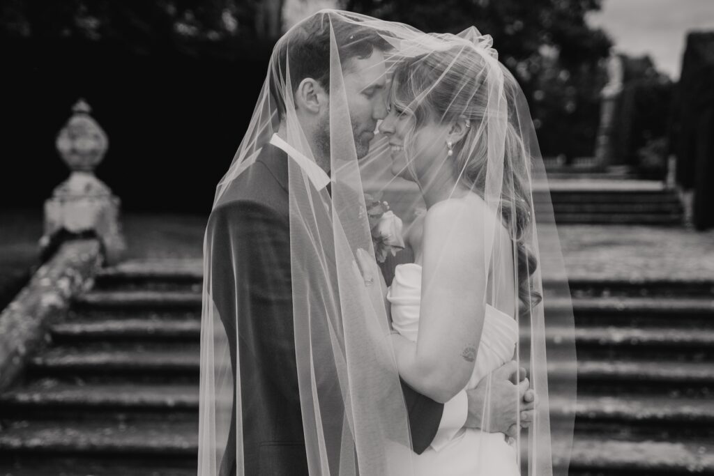 Bride and groom sharing a quiet moment under the trees in evening light