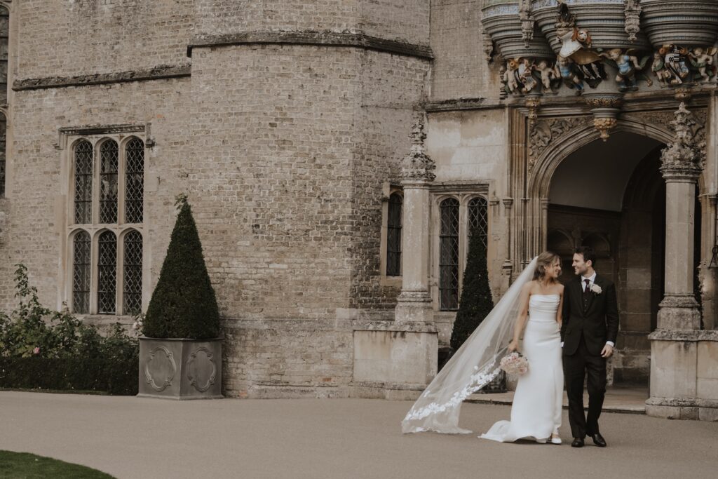Romantic portrait of the couple outside the grand front doors of Hengrave Hall