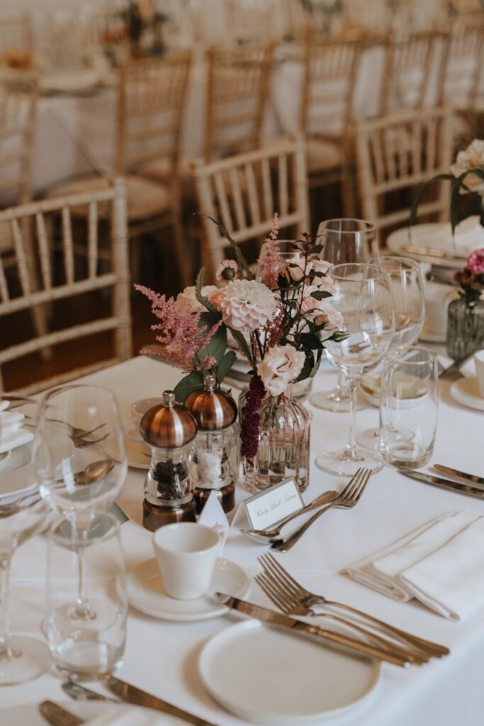 Elegant table decor with candles and bud vases in soft neutral tones