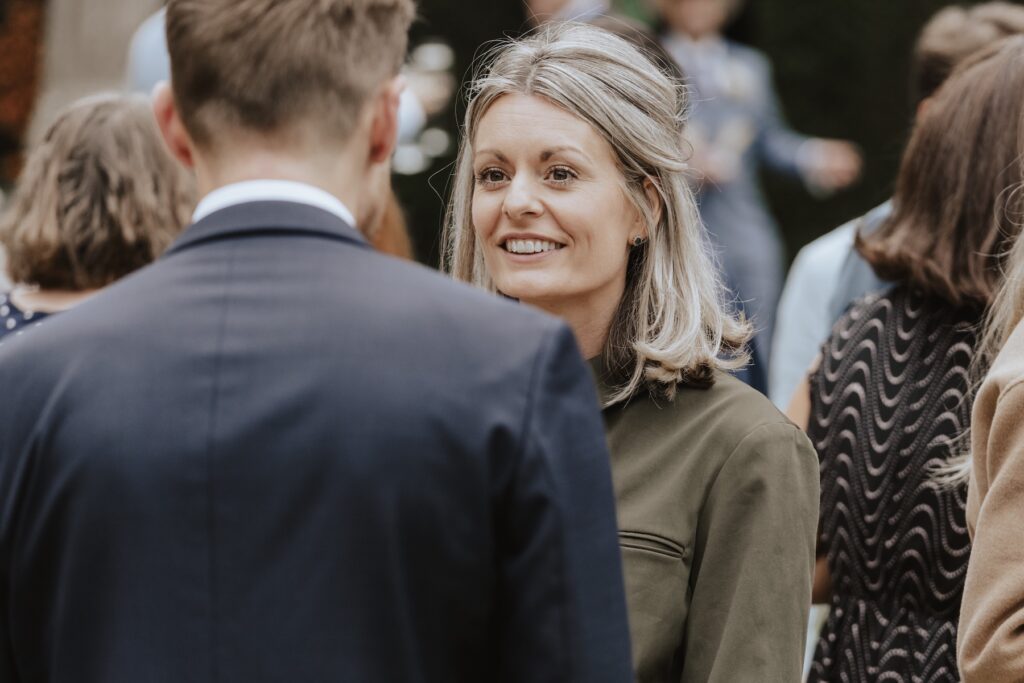 Candid laughter between friends during outdoor reception