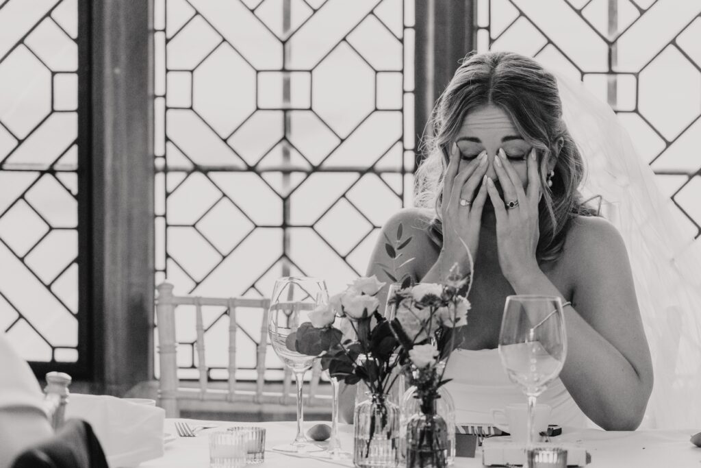 Bride wiping a tear while listening to the groom’s words