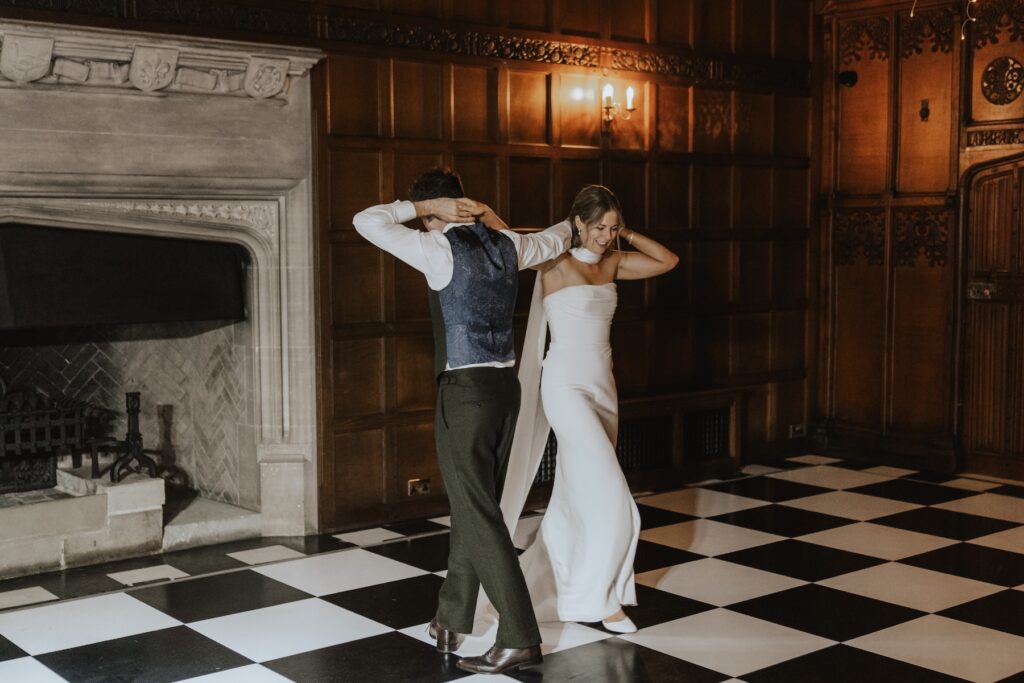 Bride and groom sharing their first dance under the lights of Hengrave Hall