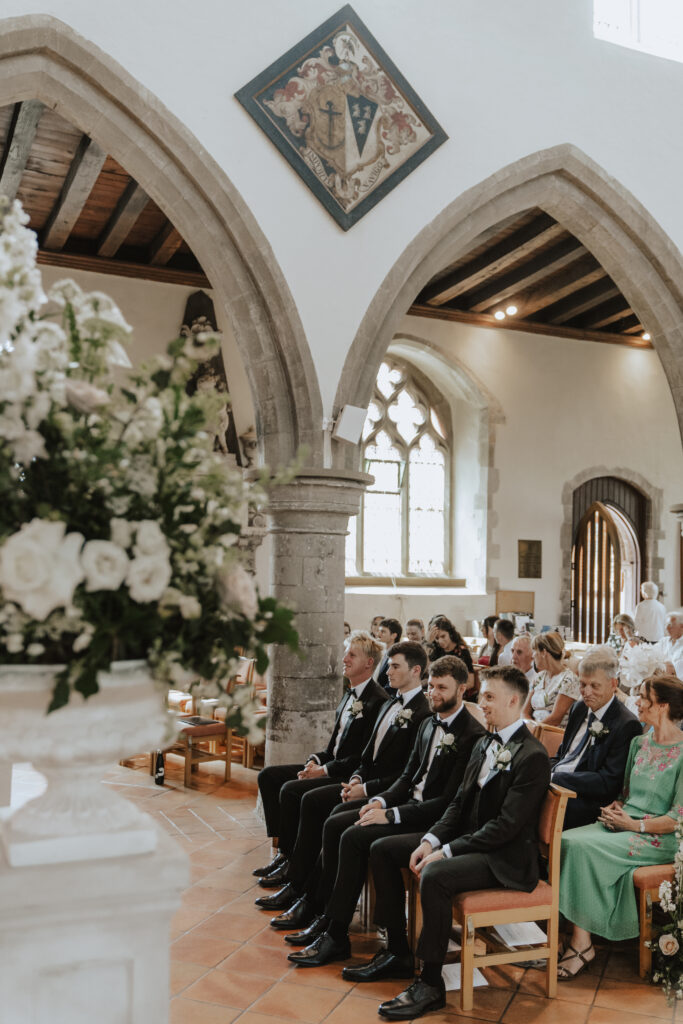 Groom greeting guests outside the church entrance