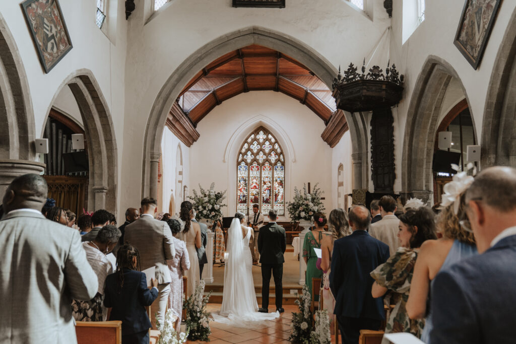 Bride and groom holding hands as they say their vows