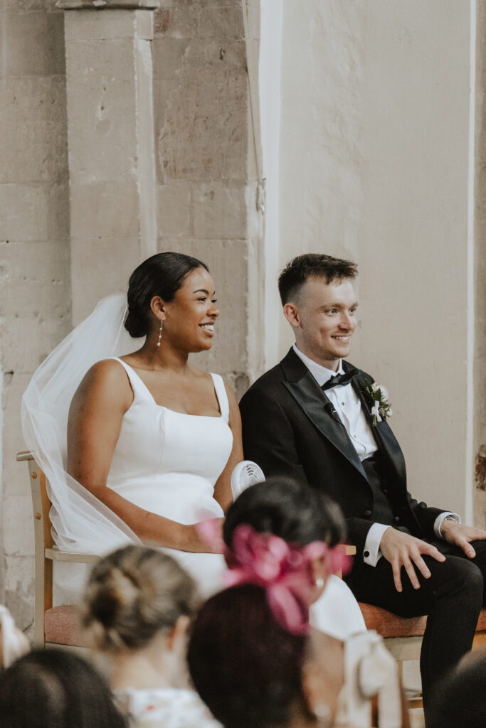 Vicar smiling while leading the ceremony at the altar