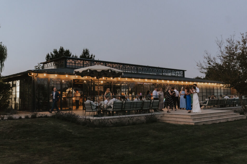 Candid photo of guests chatting and laughing on the terrace at night