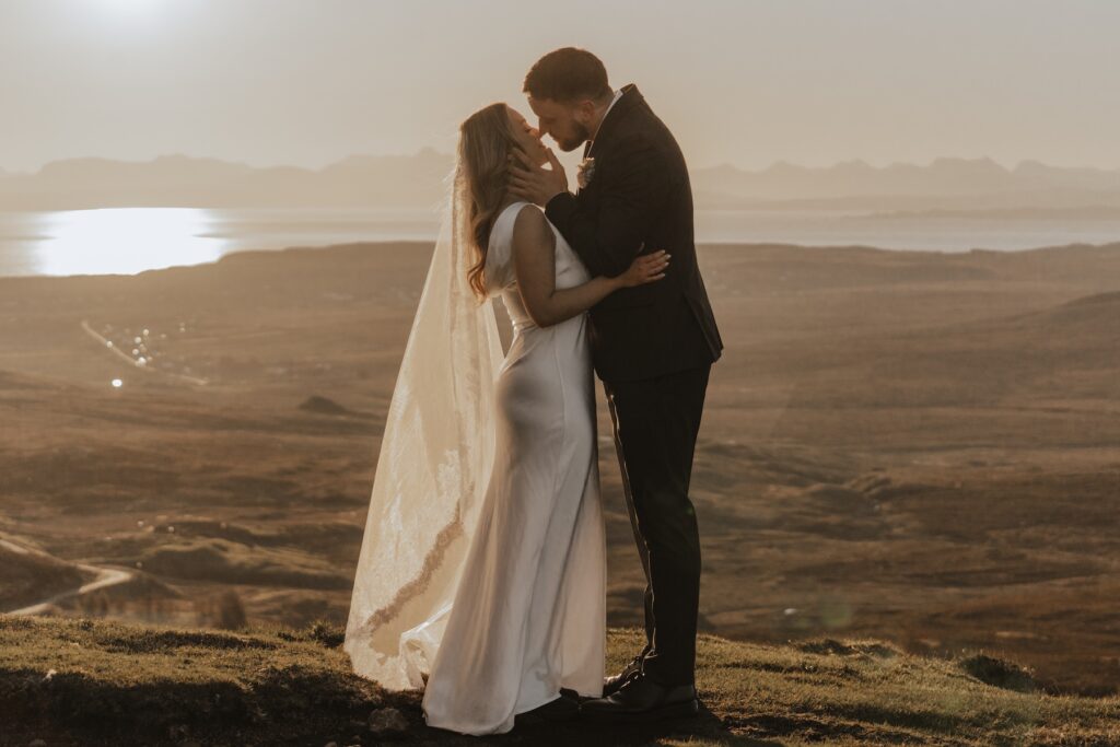 Isle of Skye elopement couple embracing on mountain ridge at sunrise