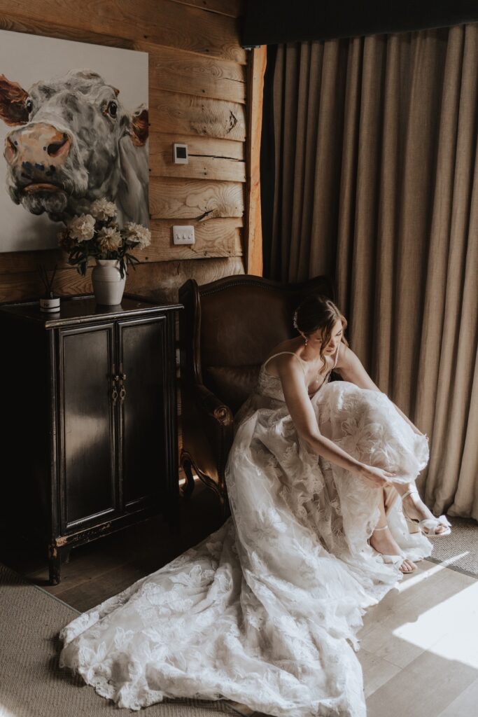 Suffolk wedding photographer capturing the bride putting her wedding shoes on