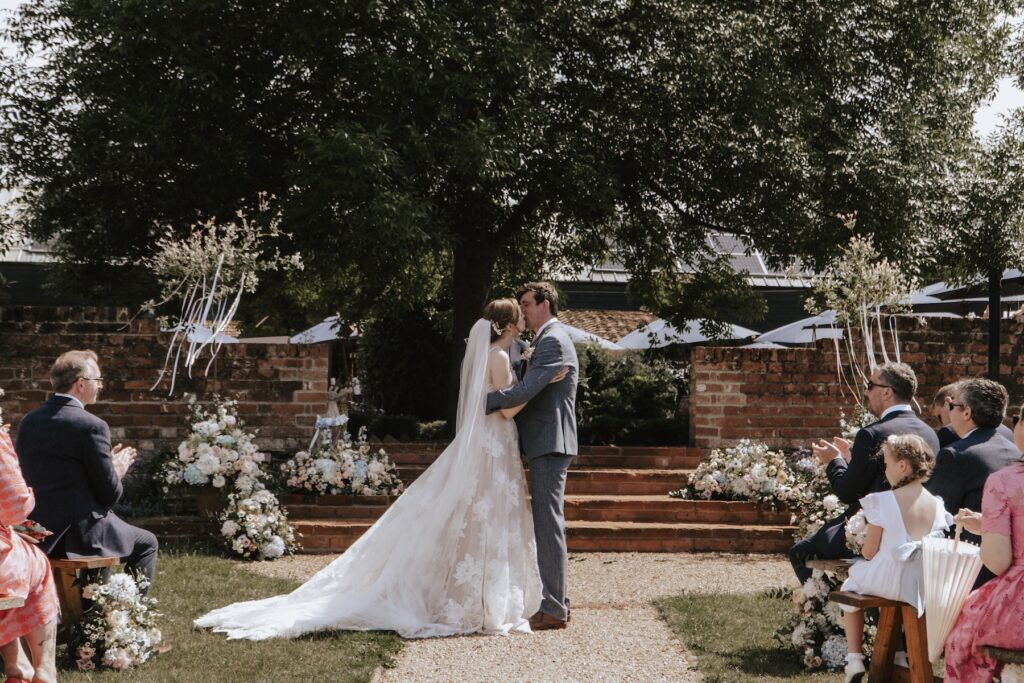The couple having their first kiss during their Jimmy's Farm ceremony