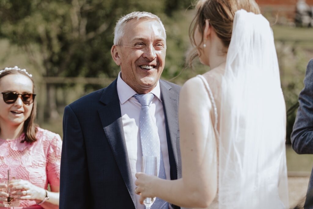 Relaxed outdoor wedding reception with champagne and sunshine in Suffolk