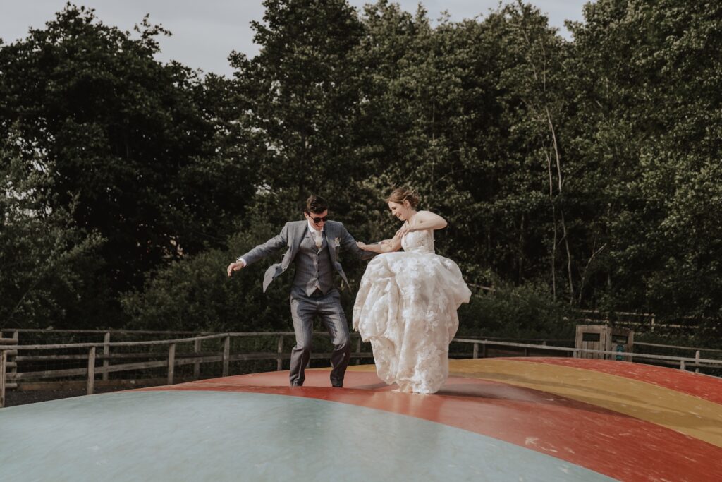 The bride and groom on the inflatables during their wedding day at Jimmy's Farm
