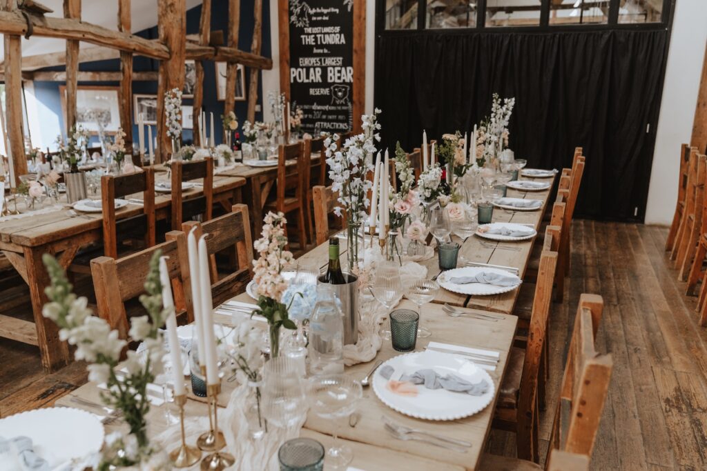 Banquet-style dinner setup with bud vases and flowers at Jimmy’s Farm wedding