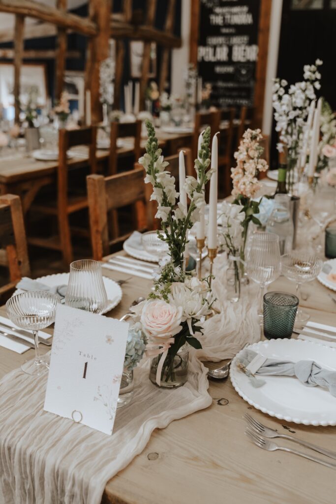 Suffolk wedding photographer capturing the dinner reception setup with bud vases and flowers at Jimmy’s Farm wedding