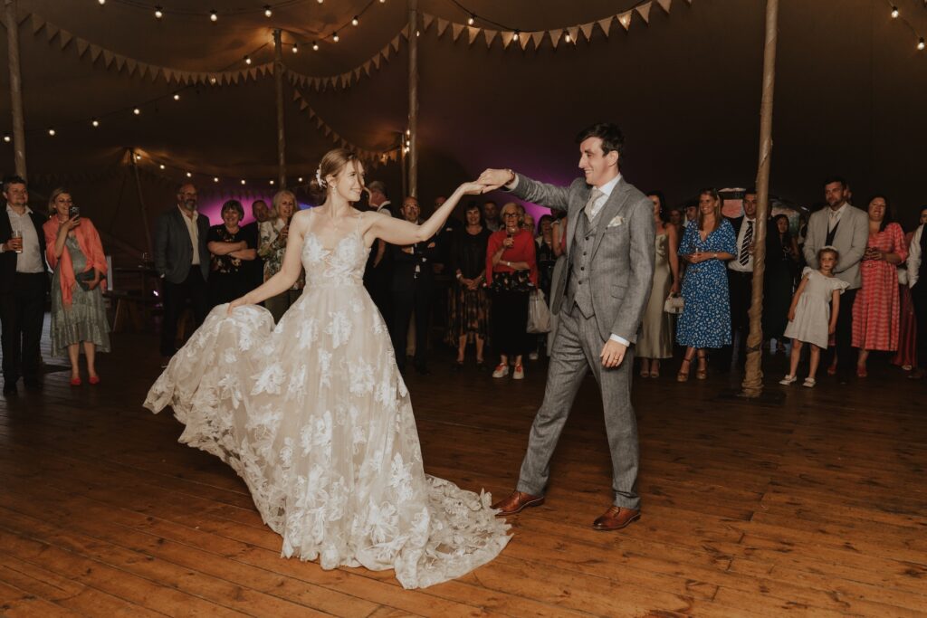 Couple’s first dance under the stretch tent with fairy lights at Jimmy’s Farm