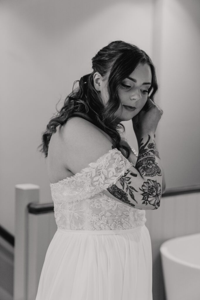 Bride putting earrings in at Seckford Hall bridal suite