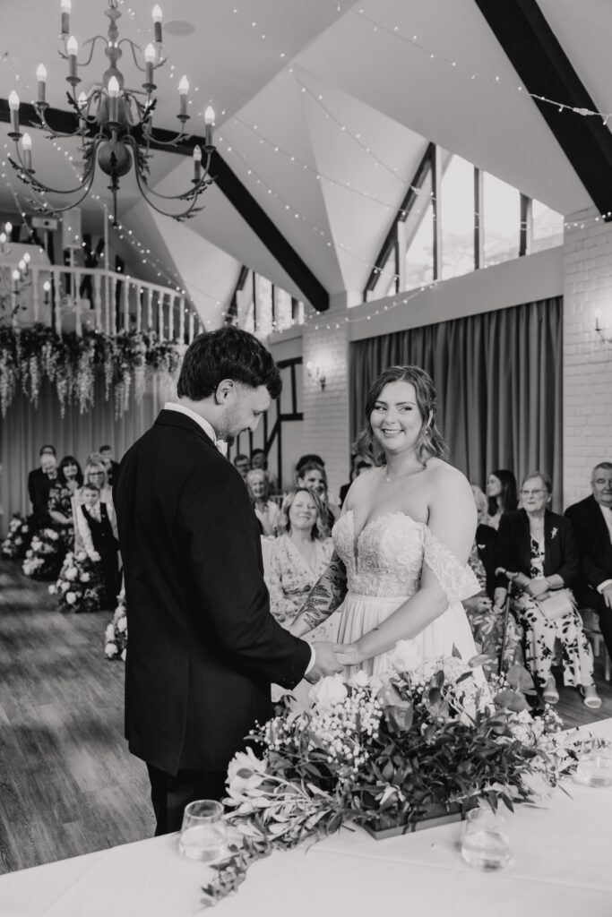 Couple exchanging rings in elegant Seckford Hall ceremony room