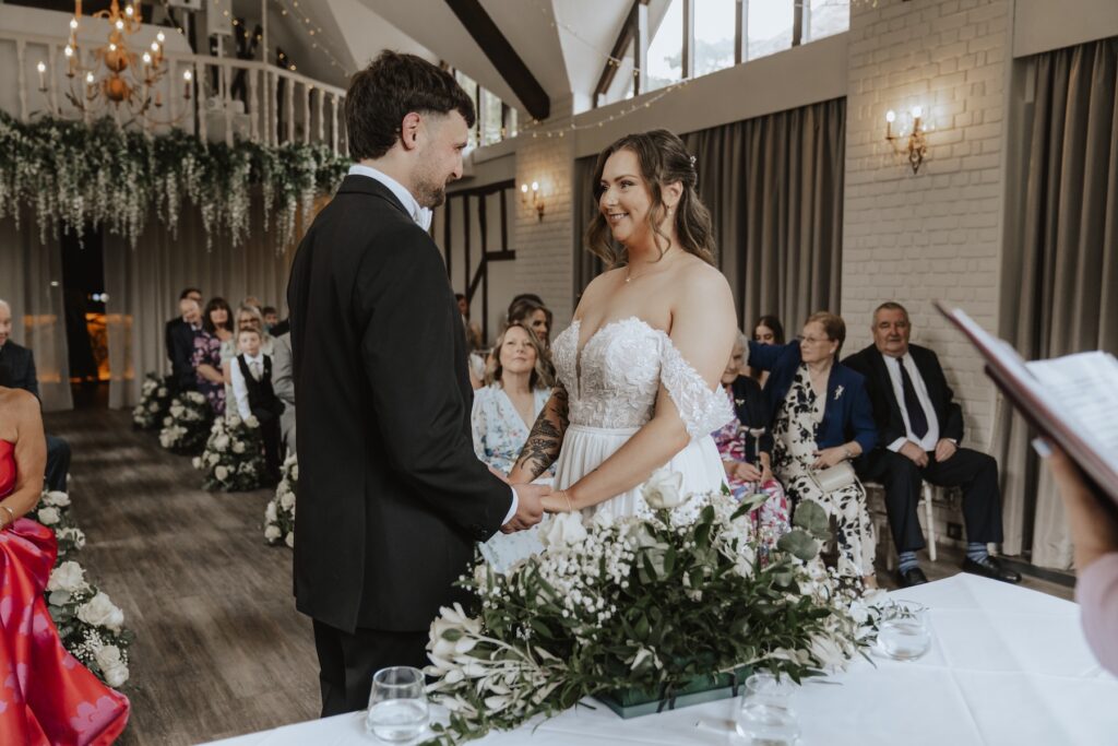 Overview of guests seated beneath Seckford Hall’s high timber ceiling during Seckford ceremony in Suffolk
