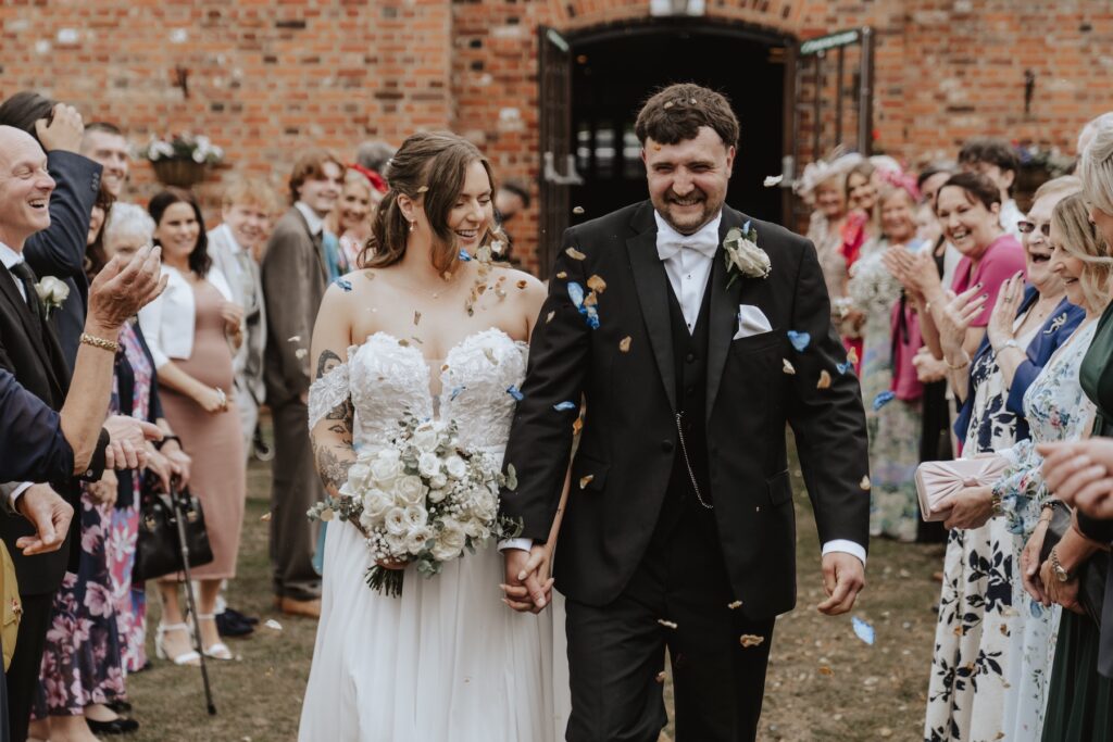 Guests cheering as confetti fills the air in Seckford gardens