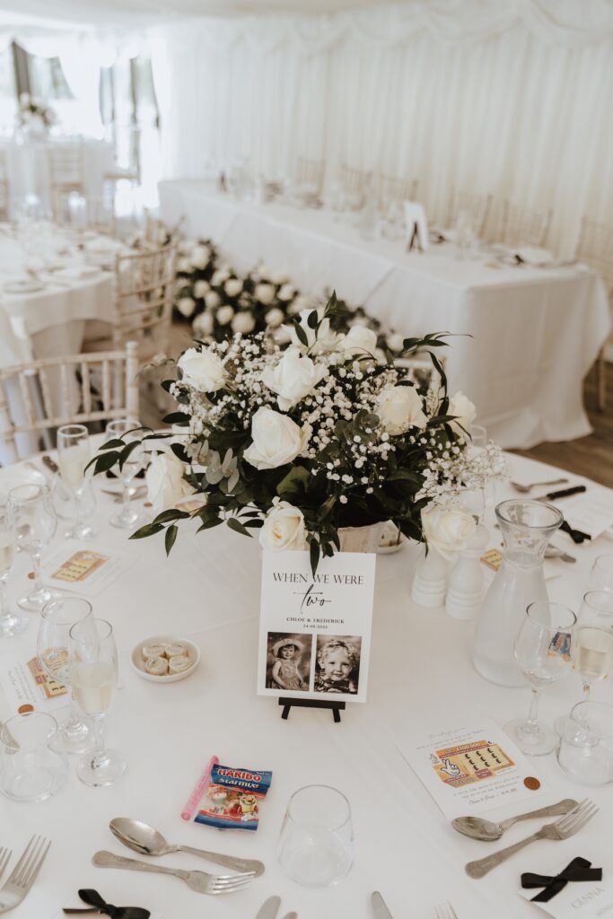 Table names with childhood photos and “When We Were 2” theme