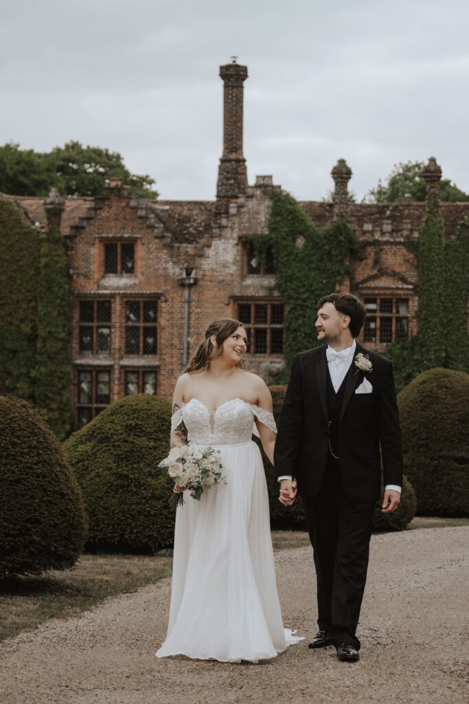 Romantic portrait of couple beside Seckford Hall’s building in Suffolk