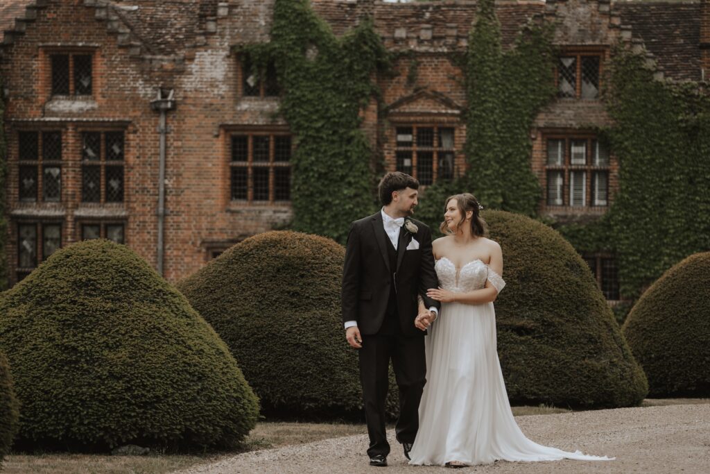 Couple framed by Seckford Hall’s ivy-covered walls
