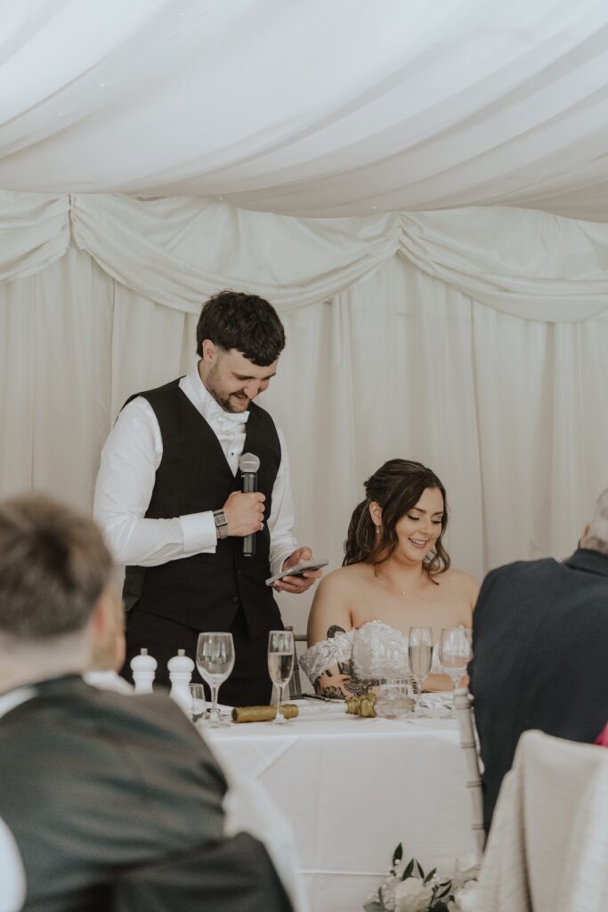 Bride smiling as she listens to heartfelt words