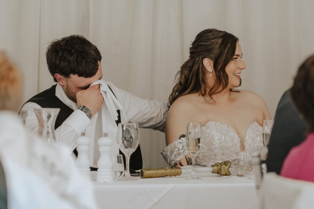 Groom wiping away a tear during emotional speech