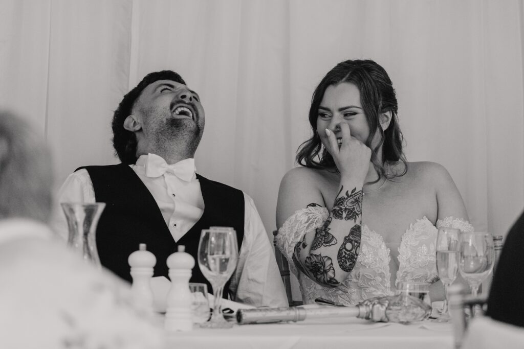 The bride and groom laughing at the best man speech
