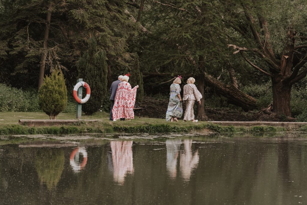 The lake at Seckford Hall with guests walking around it