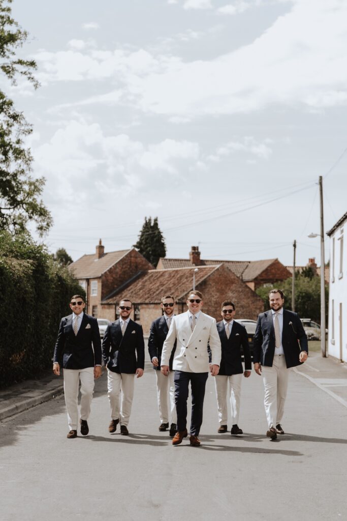 Groomsmen laughing outside the family home before heading to the local pub