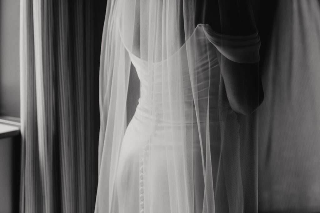 Bridesmaids helping Jess into her gown before the DIY wedding at home