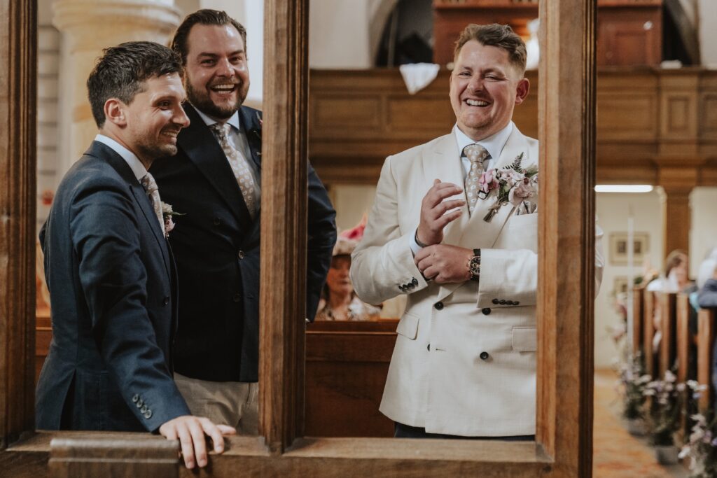 Smiling groom before bride walks down the aisle