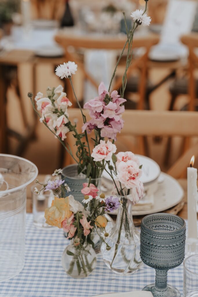 DIY wedding details with white roses and green foliage centrepieces