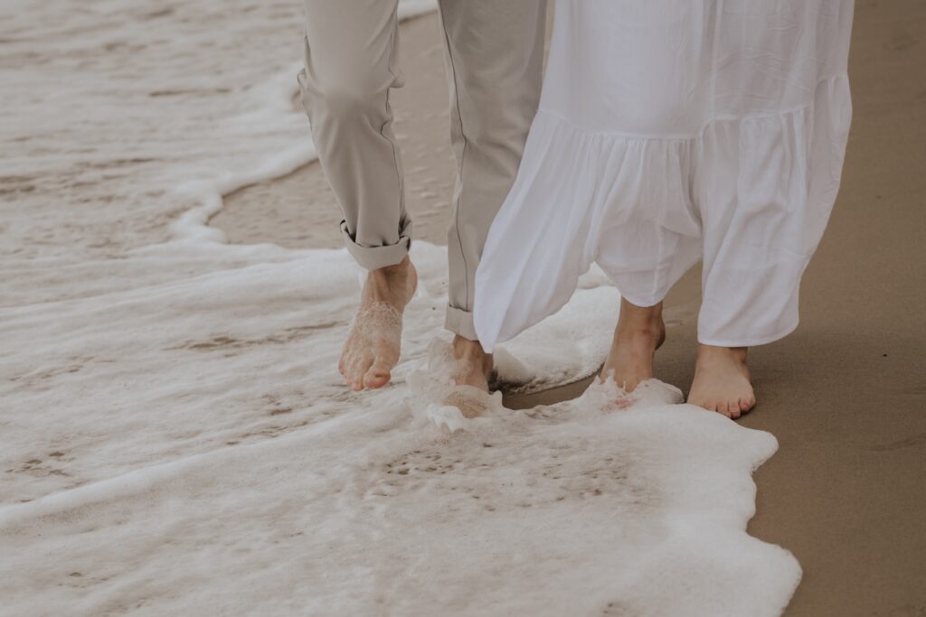 A couple walking in the sea on Southwold beach