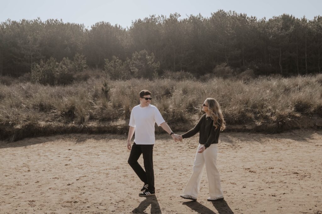 Engagement photographer capturing a couple on the beach at Holkham