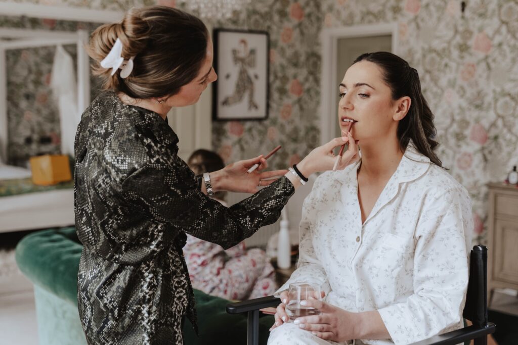 A bride getting her makeup done at Seckford Hall