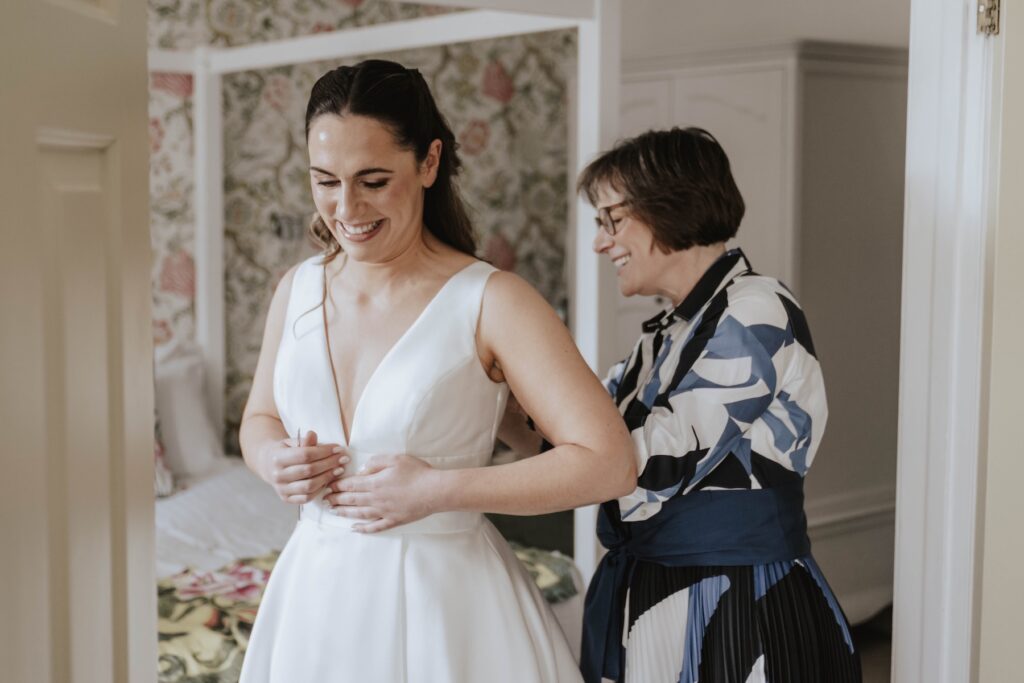 A bride getting into her wedding dress at Seckford Hall