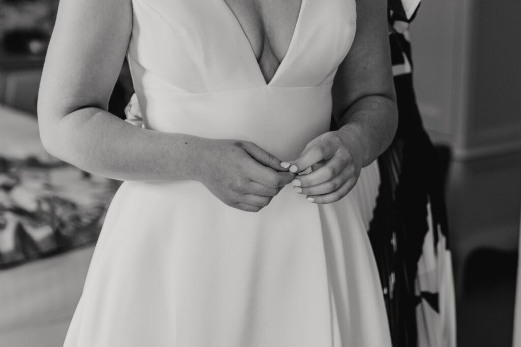 A bride getting into her wedding dress at Seckford Hall