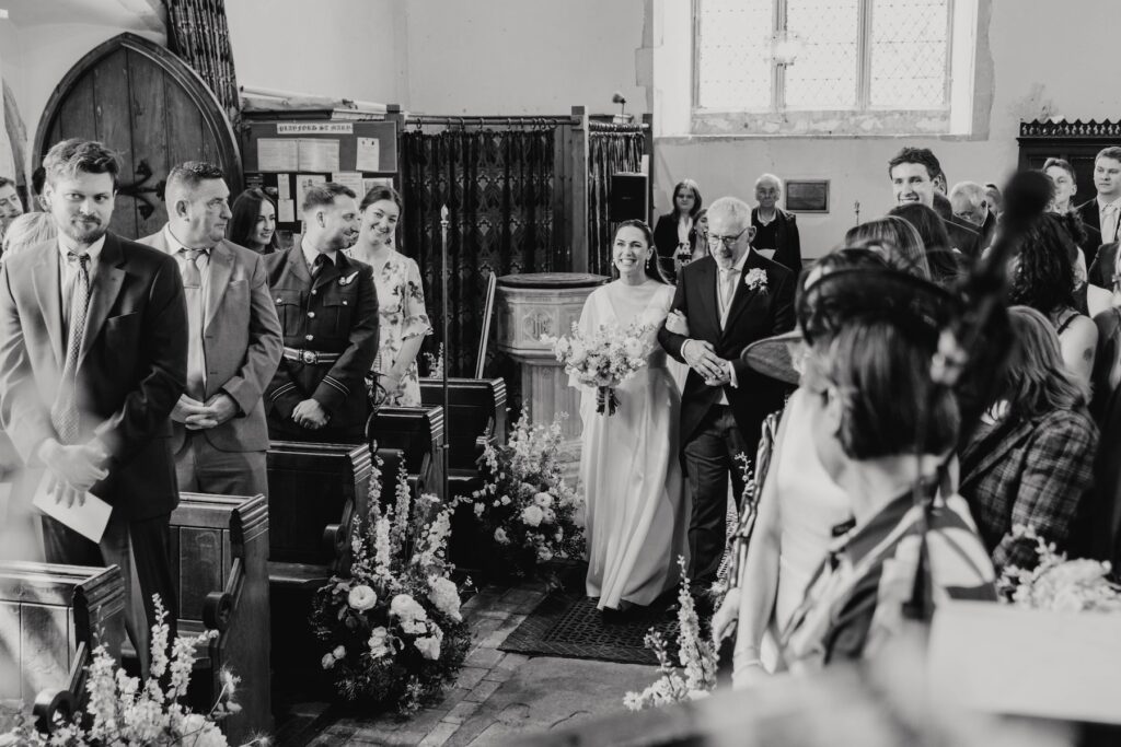 The bride walking down the aisle at a church ceremony in Suffolk