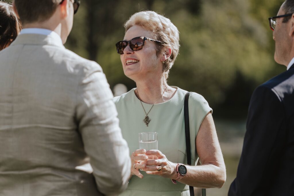 Candid moments of guests during a wedding drinks reception at Seckford Hall in Suffolk
