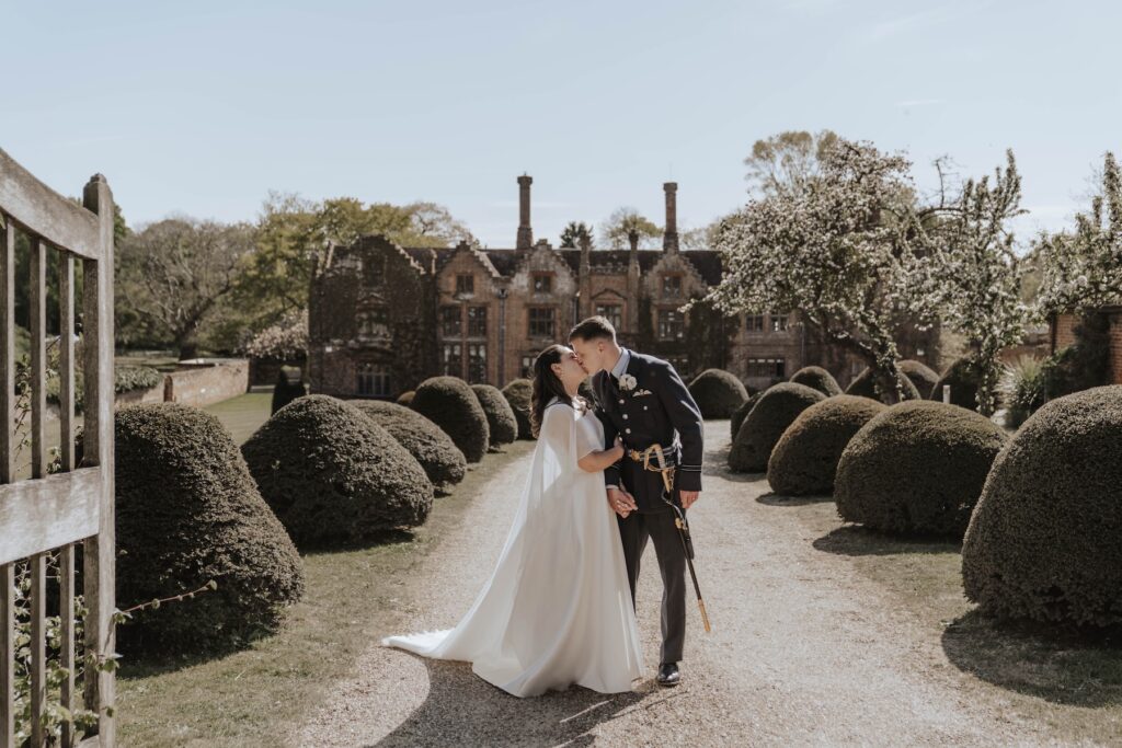 Couples portraits taken of a bride and groom on their wedding day outside Seckford Hall on the driveway