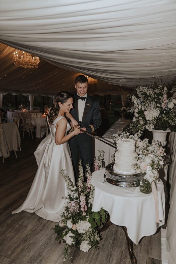 A bride and groom at Seckford Hall cutting their wedding cake