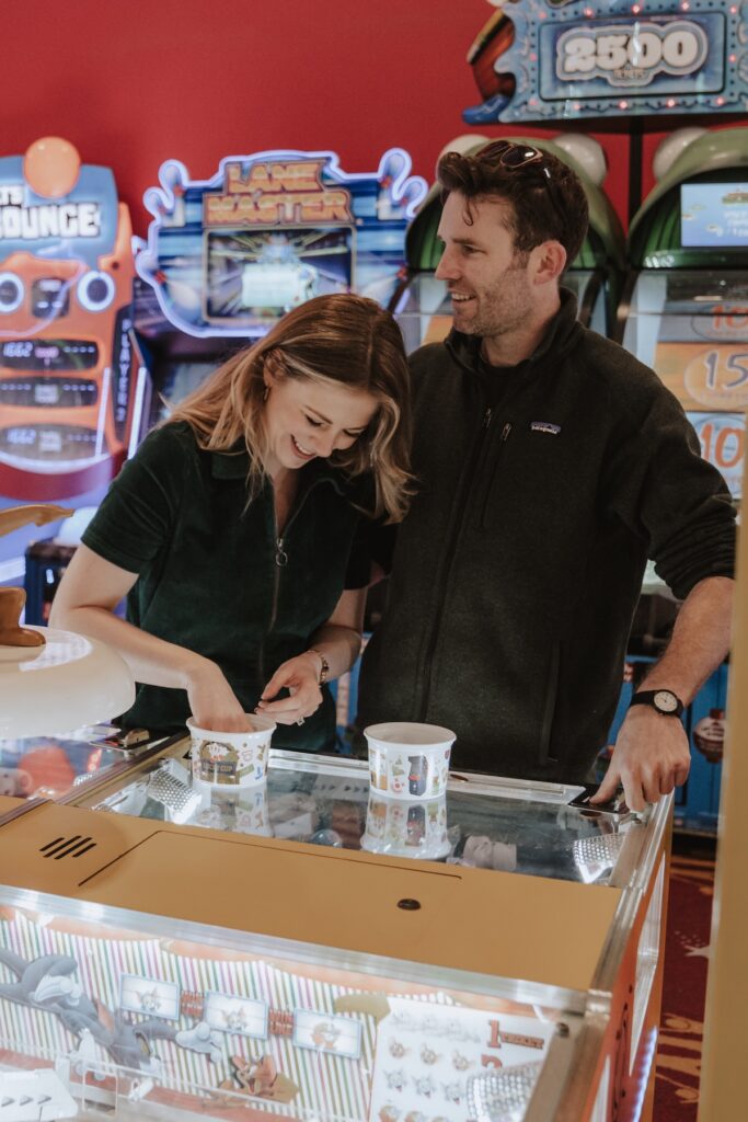 Suffolk engagement photographer capturing a couple playing with the arcade