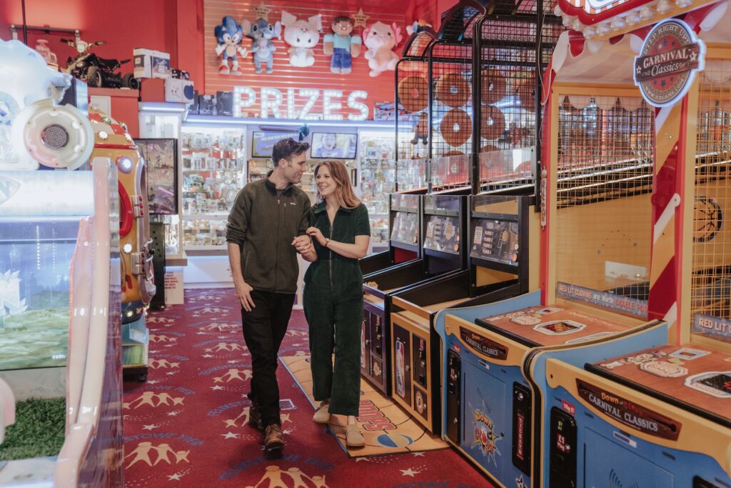 A couple walking through Felixstowe arcade during their engagement session