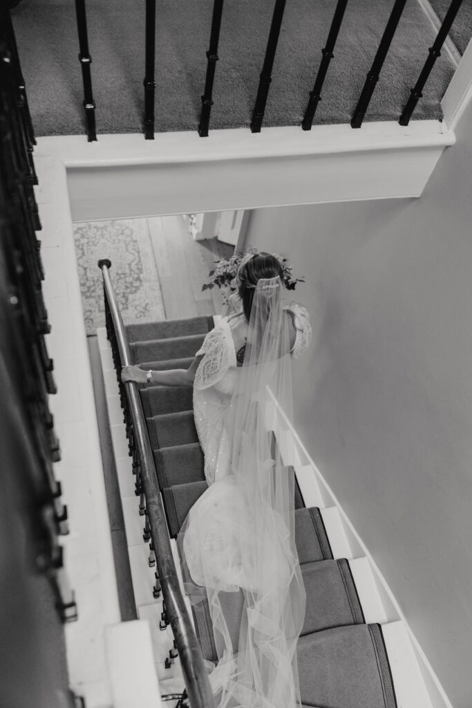 Bride walking down the stairs in the main house at Dunglass Estate
